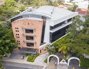 Fusión de texturas en fachada corporativa que combina ladrillo visto con modernos ventanales, por nuestra desarrolladora inmobiliaria. Edificio de oficinas contemporáneo con fachada de ladrillo y vidrio, un diseño de nuestra desarrolladora inmobiliaria.
